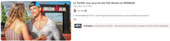 Capture d'écran d'une vidéo YouTube d'Eric Flag intitulée « Le Terrible Jour où je ne suis PAS devenu un IRONMAN. ». La miniature montre le vidéaste en tenue de sport et en larmes, face à une femme qui pose sa main sur son torse. En arrière-plan, on aperçoit une arche de course marquée du logo « IRONMAN ».