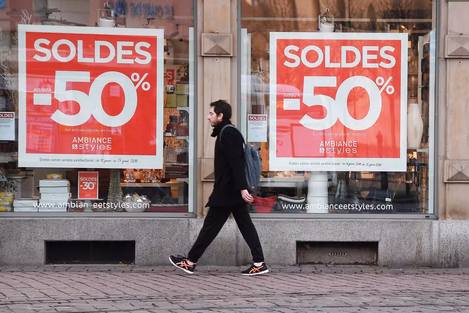 Photo d’une promotion de soldes affichée sur la devanture d'un magasin, en rouge.