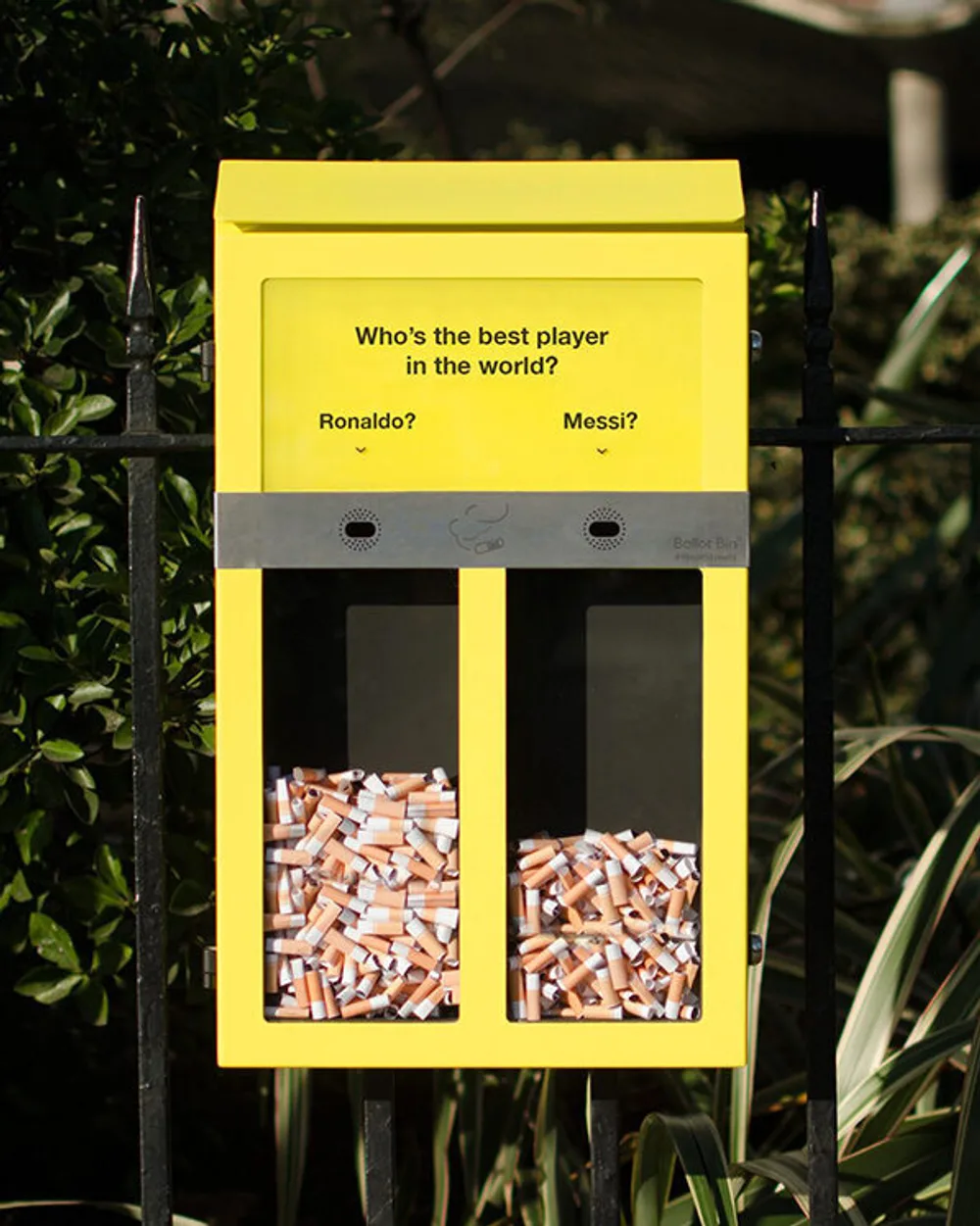 Cendrier public interactif proposant de voter entre deux options (« Ronaldo » ou « Messi »). Les fumeurs jettent leur mégot dans l’une des deux cases